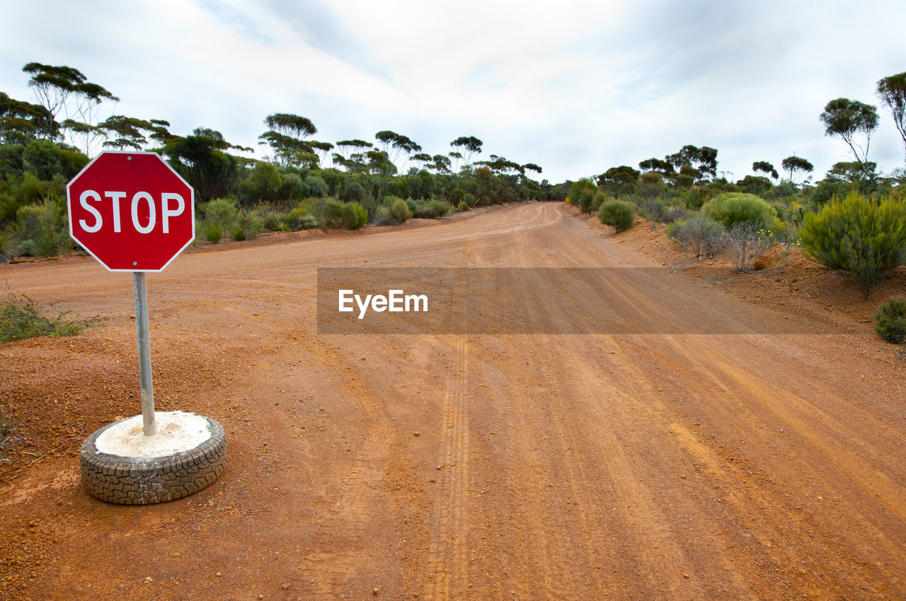 ROAD SIGN AGAINST TREES AND PLANTS