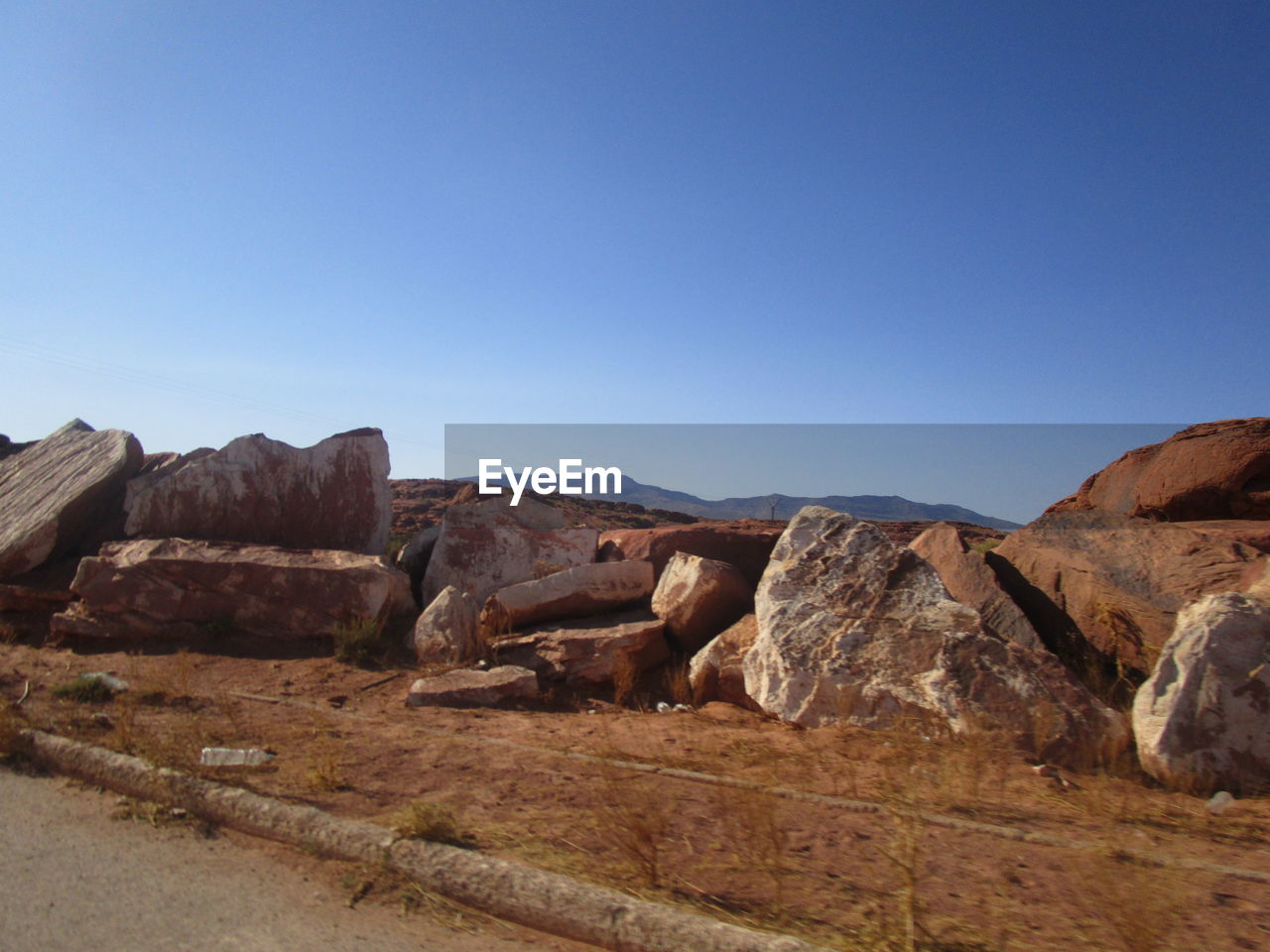 Rock formations on landscape against clear blue sky