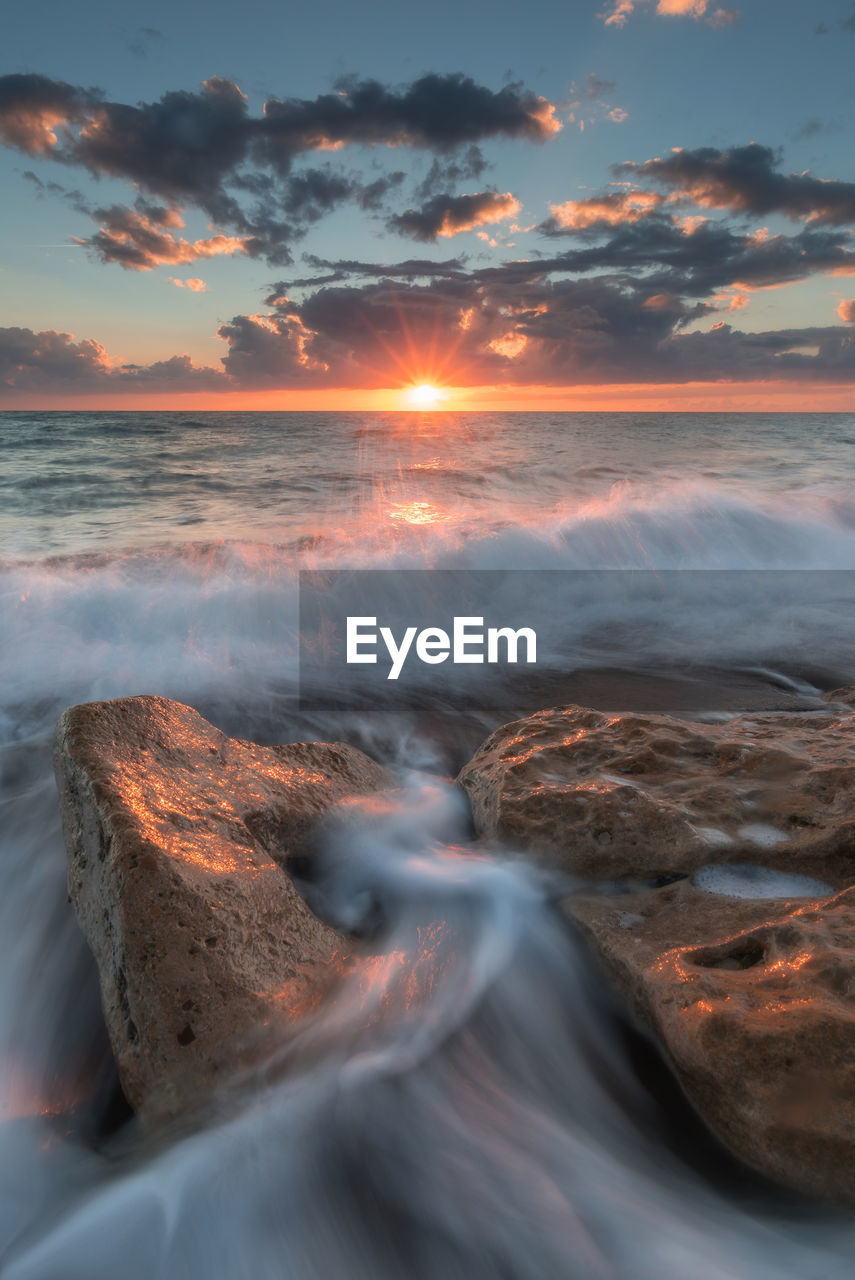 Close-up of sea against sky during sunset