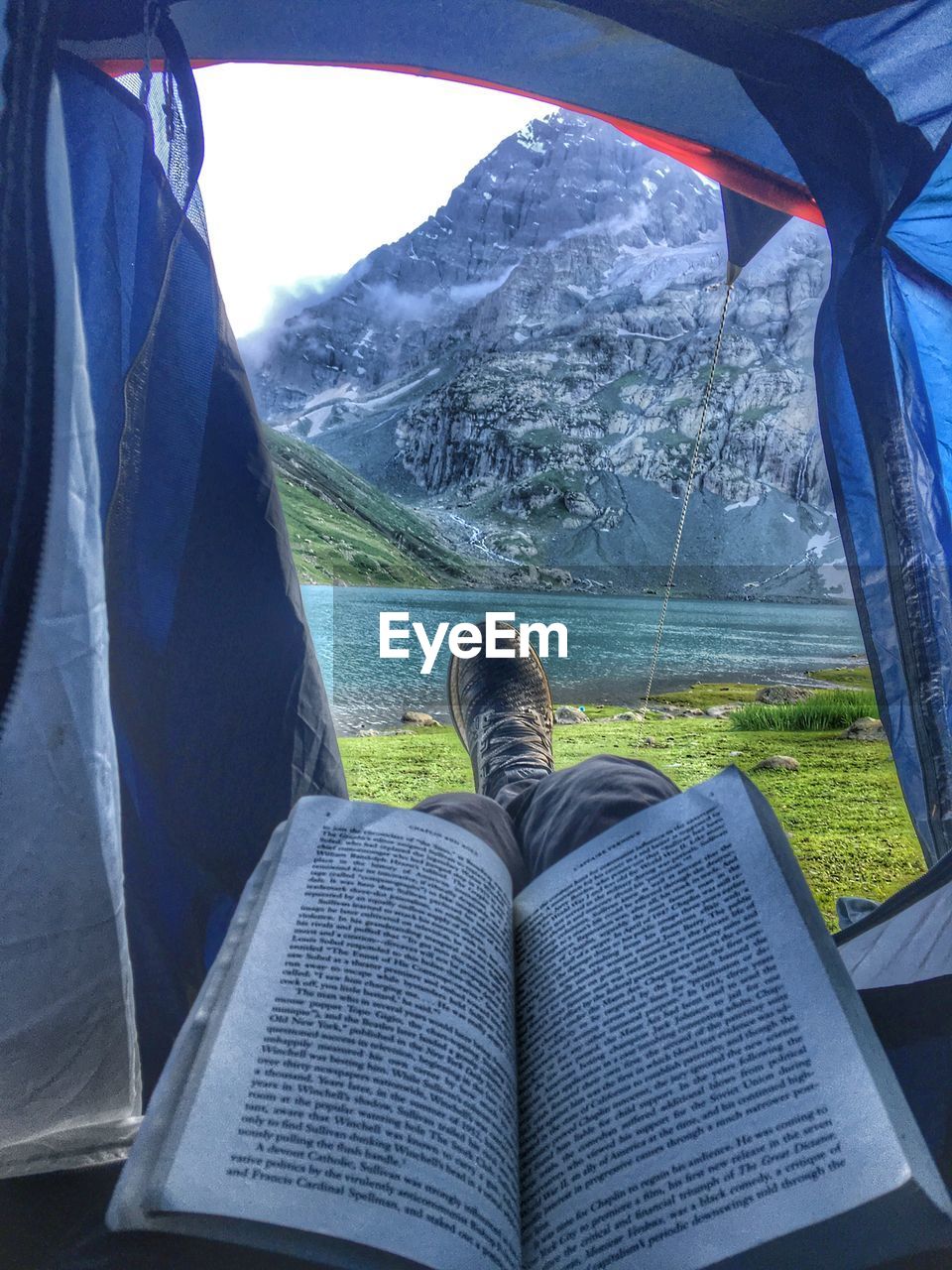 Low section of person with book in tent