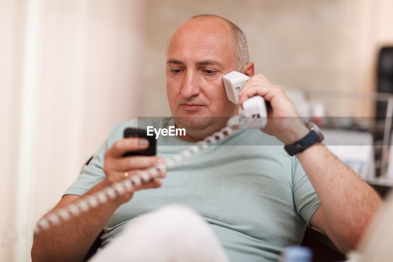 Businessman talking on landline phone 