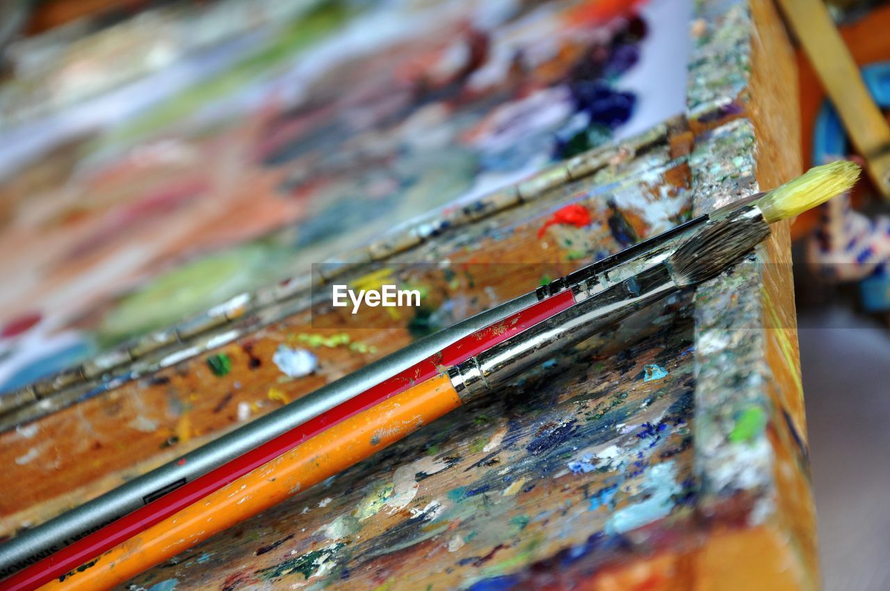 Close-up of paintbrushes on dirty wooden table