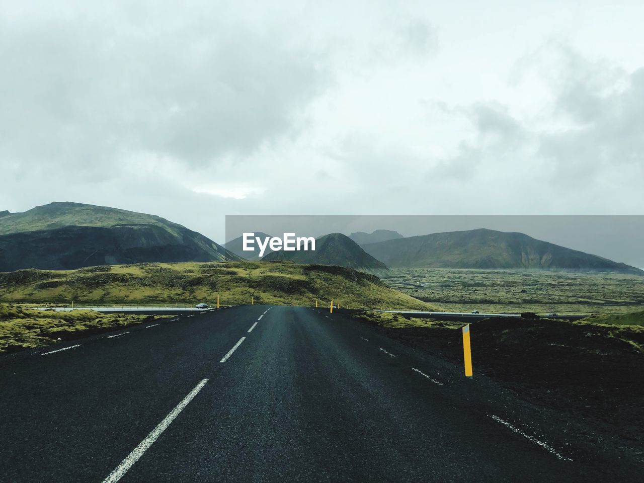 Road leading towards mountains against sky