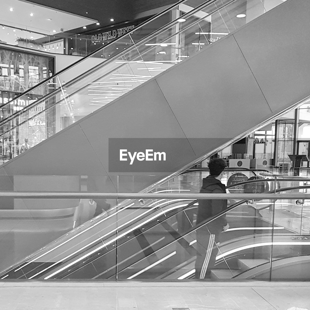LOW ANGLE VIEW OF WOMAN ON ESCALATOR AT RAILROAD STATION