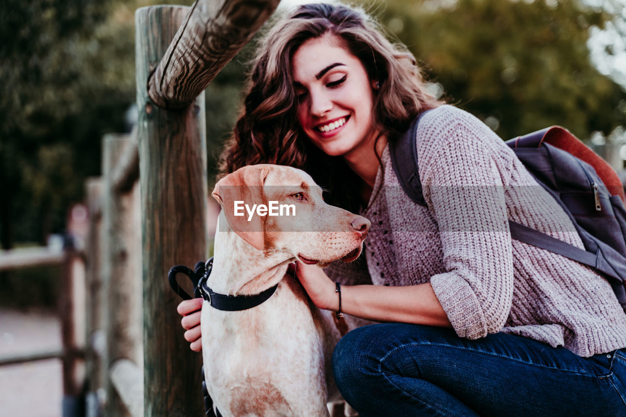 PORTRAIT OF YOUNG WOMAN WITH DOG ON HAIR