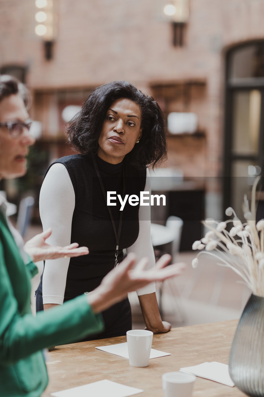 Mature businesswoman discussing with female colleague at corporate office