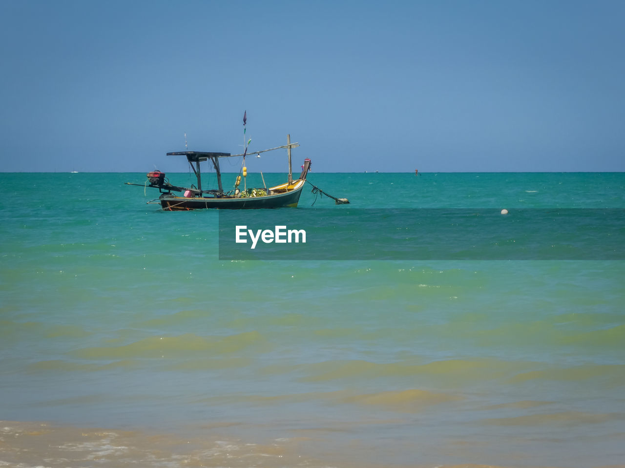 Boat sailing in sea against clear sky