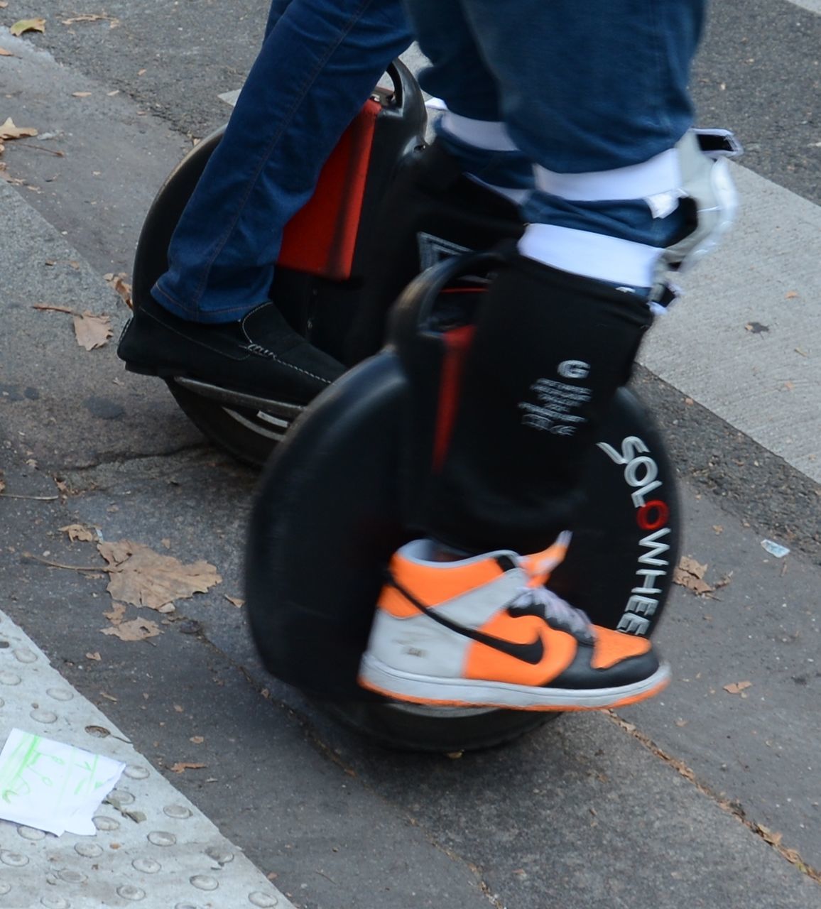 LOW SECTION OF MAN WEARING SHOES ON ASPHALT