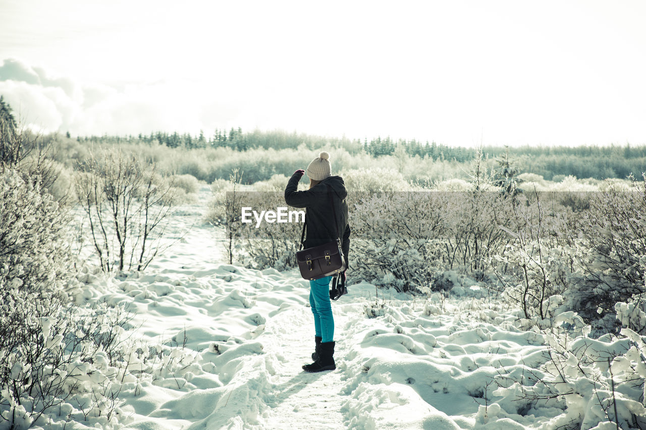 Full length of woman standing on snow field