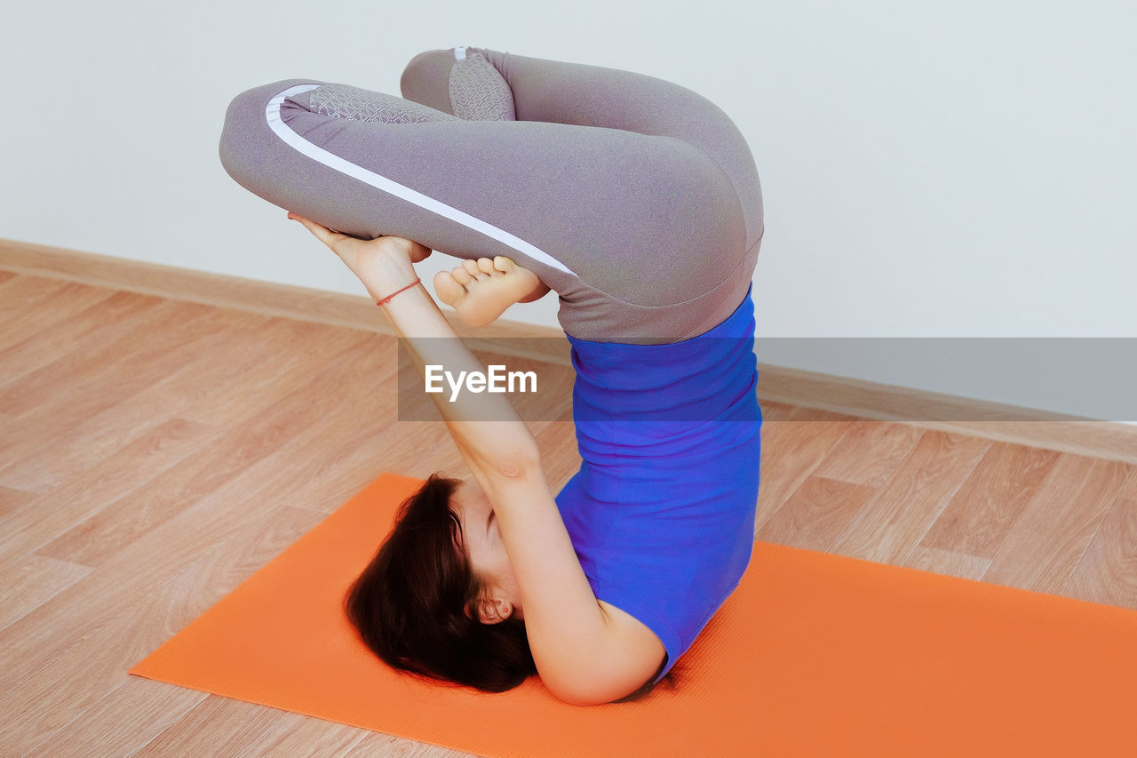 HIGH ANGLE VIEW OF WOMAN RELAXING AT HOME