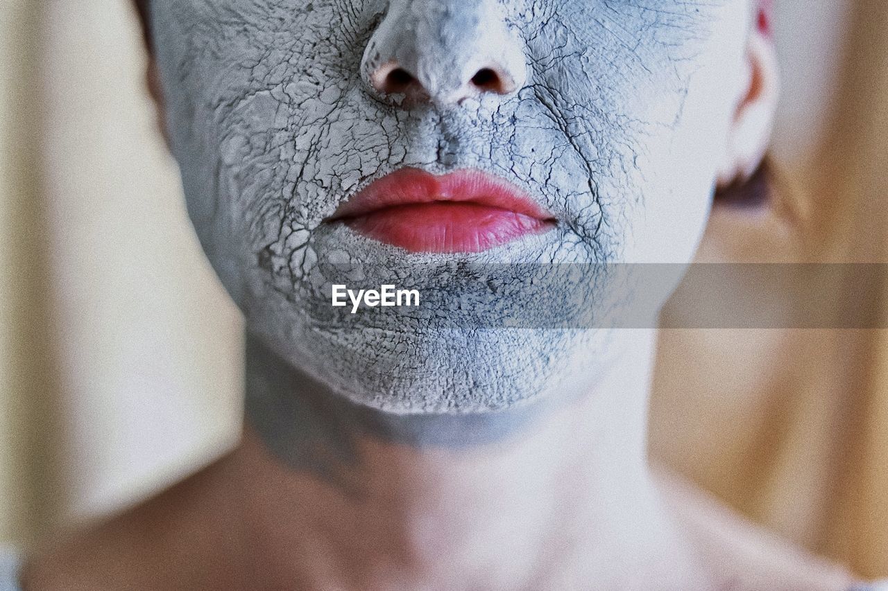 Close-up portrait of a woman with a clay mask 