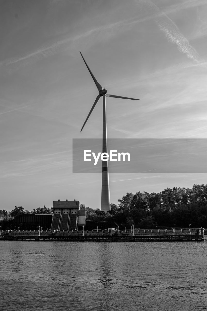 turbine, wind turbine, wind power, sky, renewable energy, environmental conservation, environment, alternative energy, power generation, water, architecture, built structure, nature, windmill, black and white, landscape, monochrome, building exterior, cloud, monochrome photography, no people, technology, industry, wind, machine, outdoors, beauty in nature, city, river, mill, day, power in nature, building, travel destinations, business finance and industry, plant, environmental issues, social issues, electricity, tree, waterfront