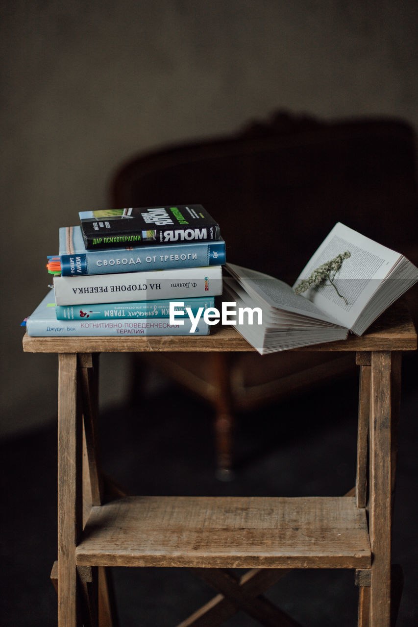 CLOSE-UP OF OPEN BOOK ON TABLE AT HOME