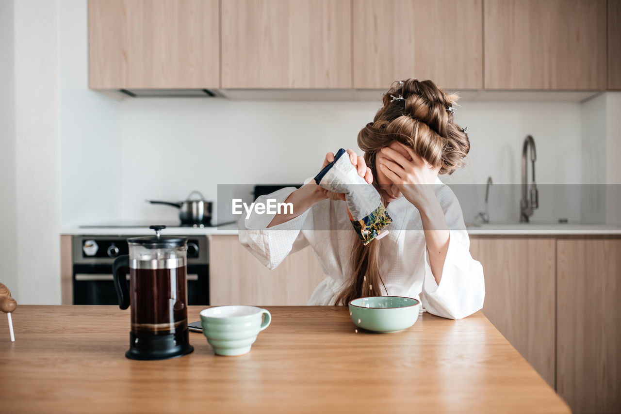 Woman with head in hands sitting at home