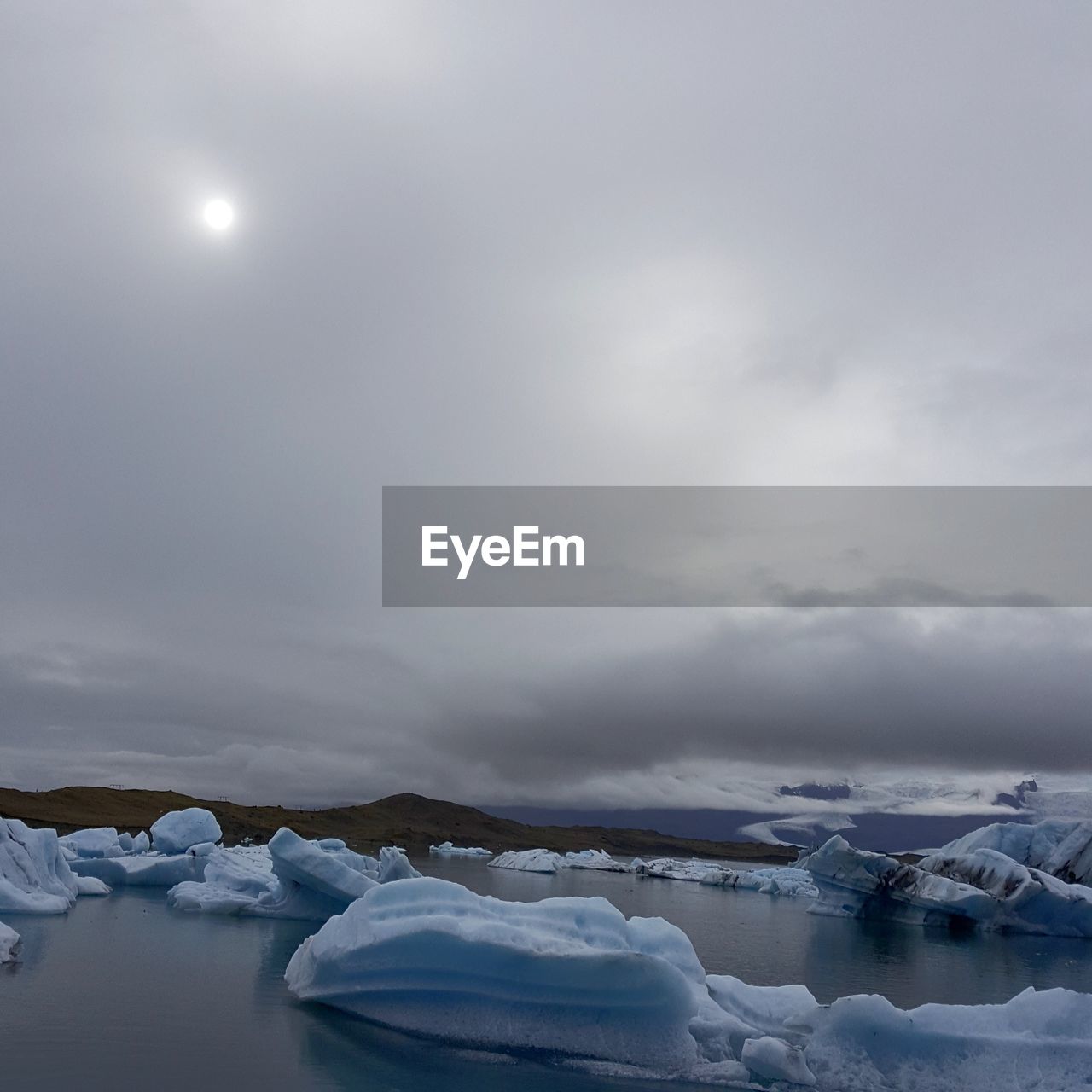 Frozen lake against sky during winter