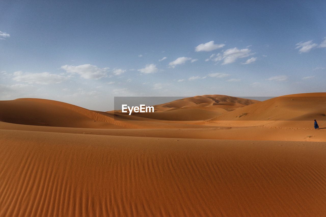 Sand dunes in desert against sky