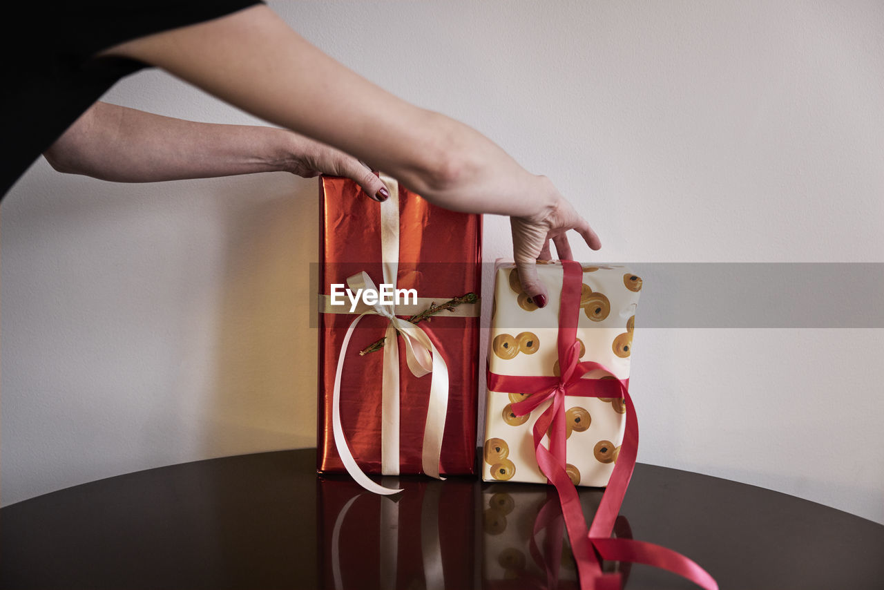 Person putting christmas presents on table