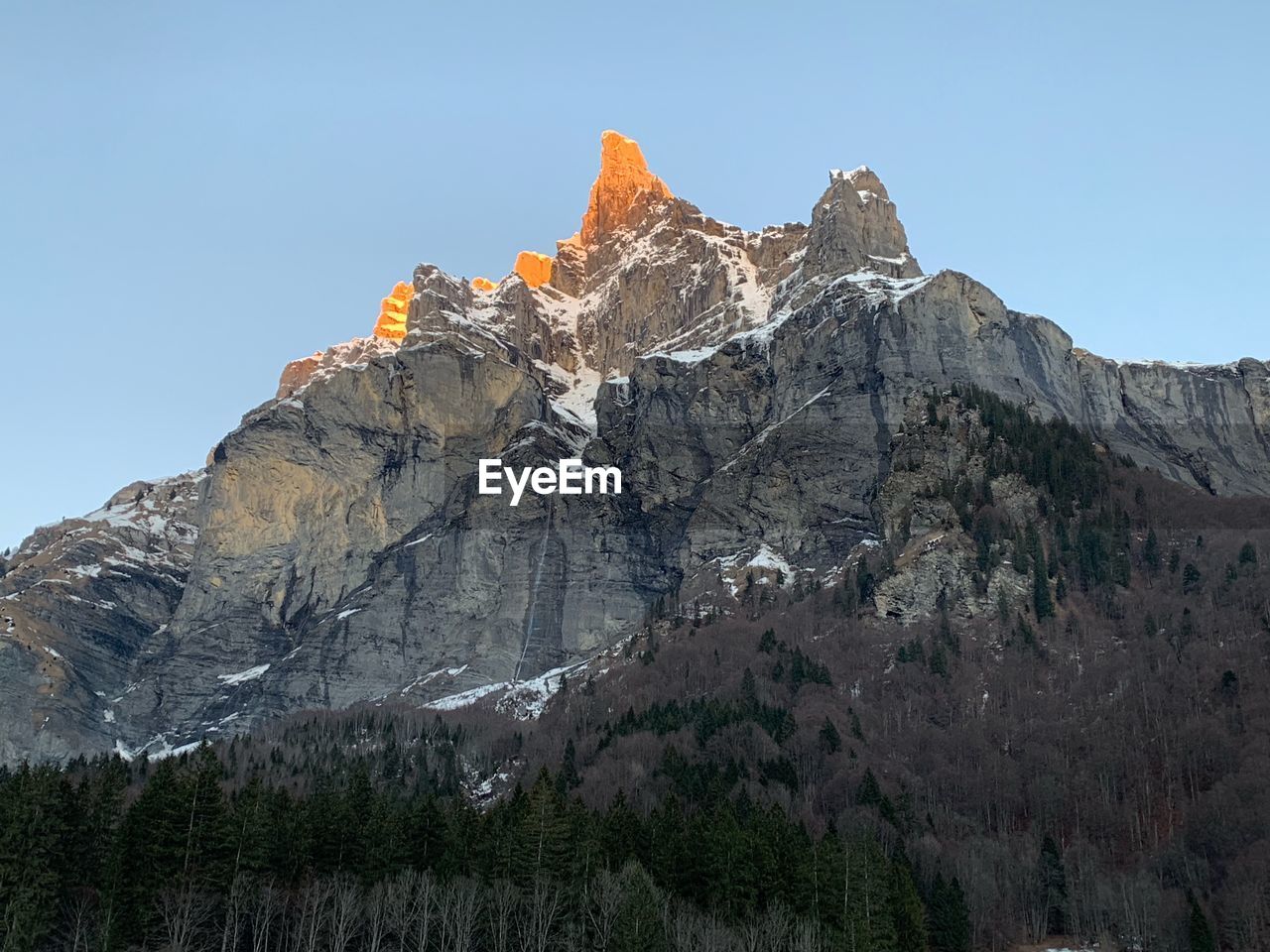 Low angle view of rocky mountain against clear sky