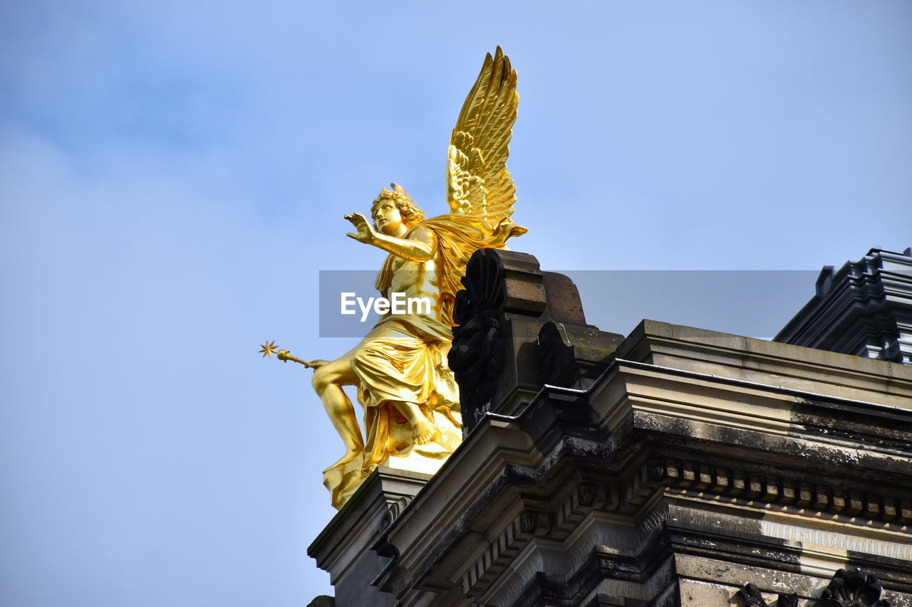 LOW ANGLE VIEW OF STATUE AGAINST BUILDING