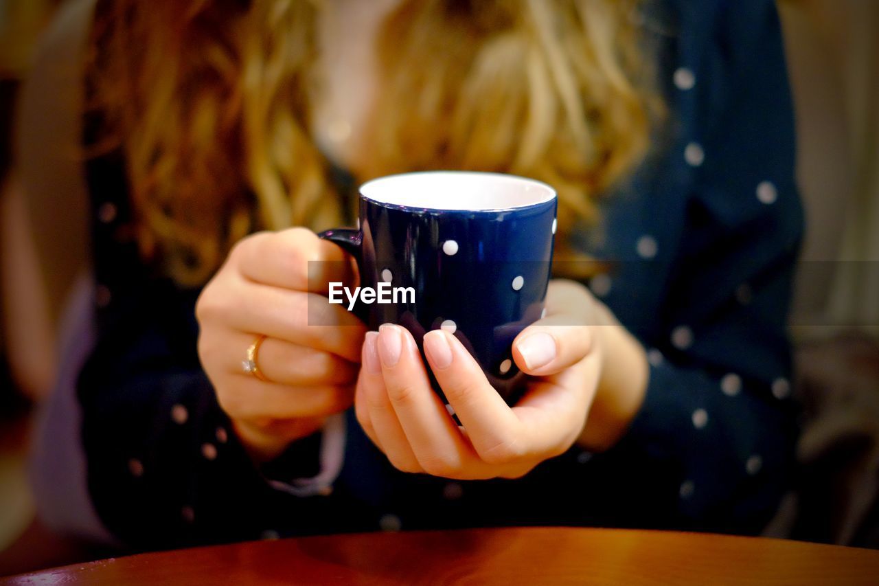 Midsection of woman holding tea cup