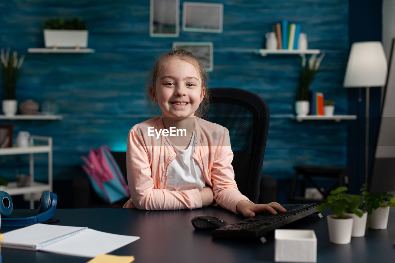 Portrait of smiling boy sitting at table