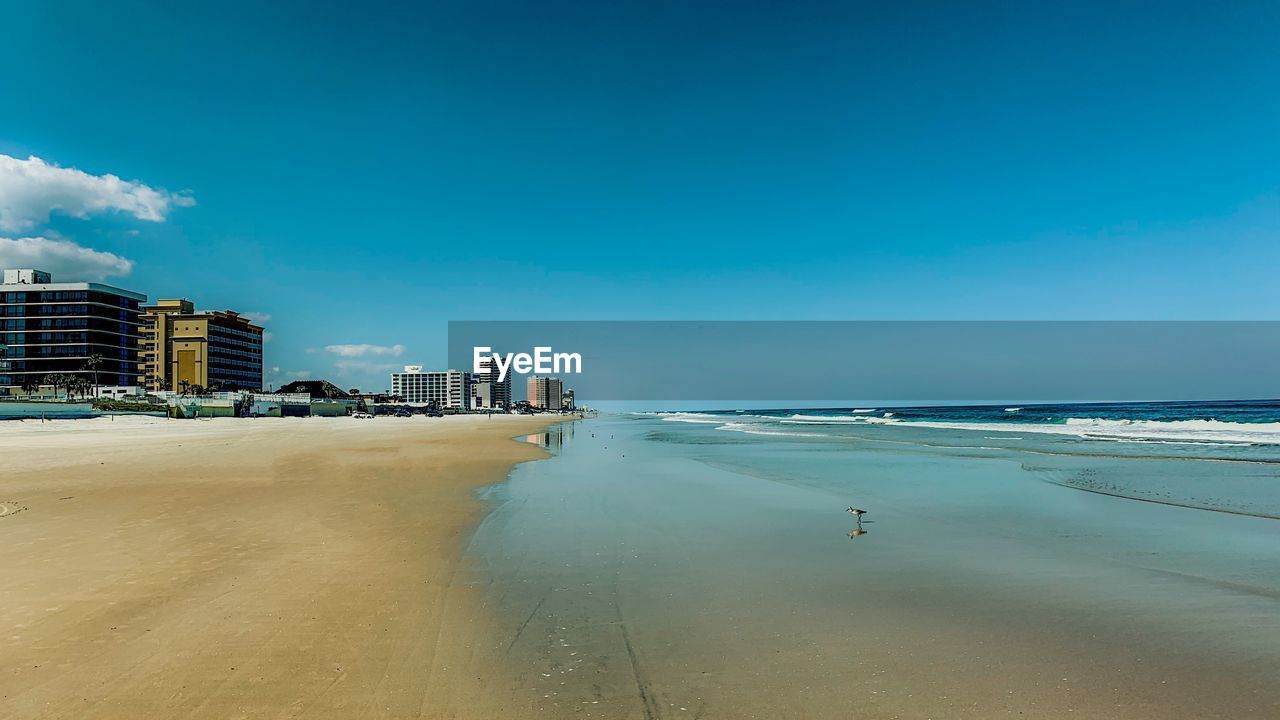 SCENIC VIEW OF BEACH BY BUILDINGS AGAINST SKY