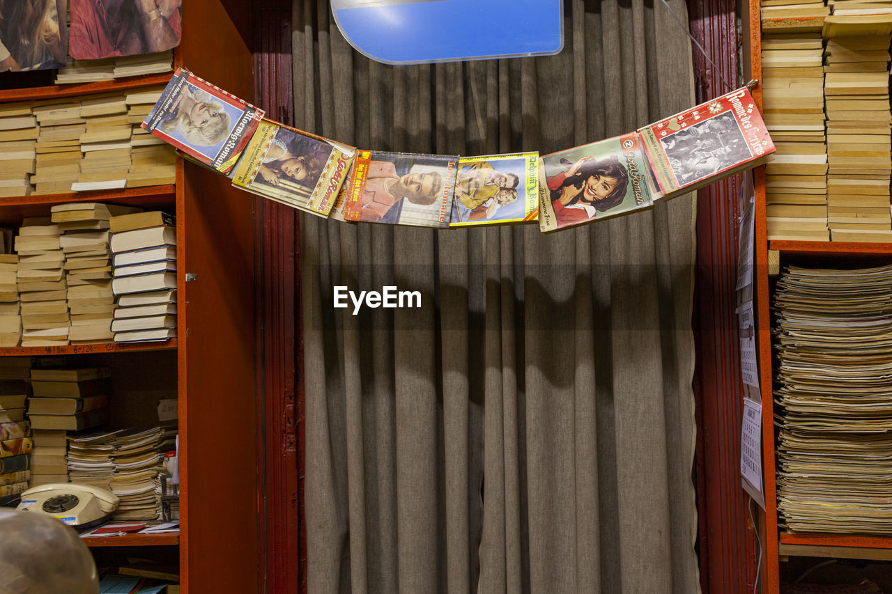 CLOSE-UP OF BOOKS ON SHELF AT HOME