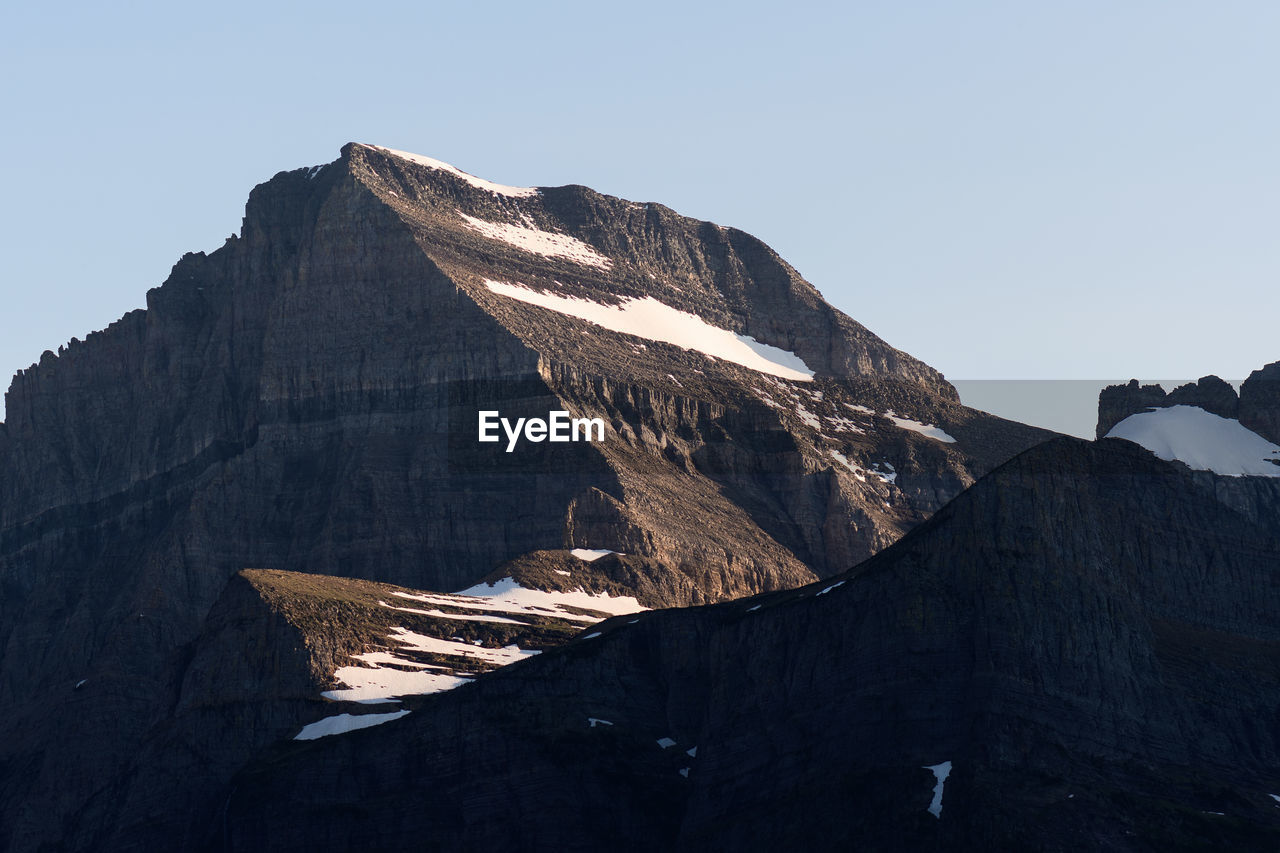 Low angle view of mountain range against clear sky