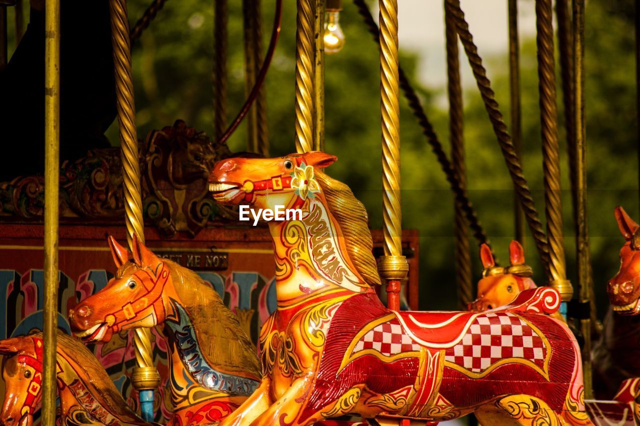 CLOSE-UP OF CAROUSEL HORSES IN AMUSEMENT PARK