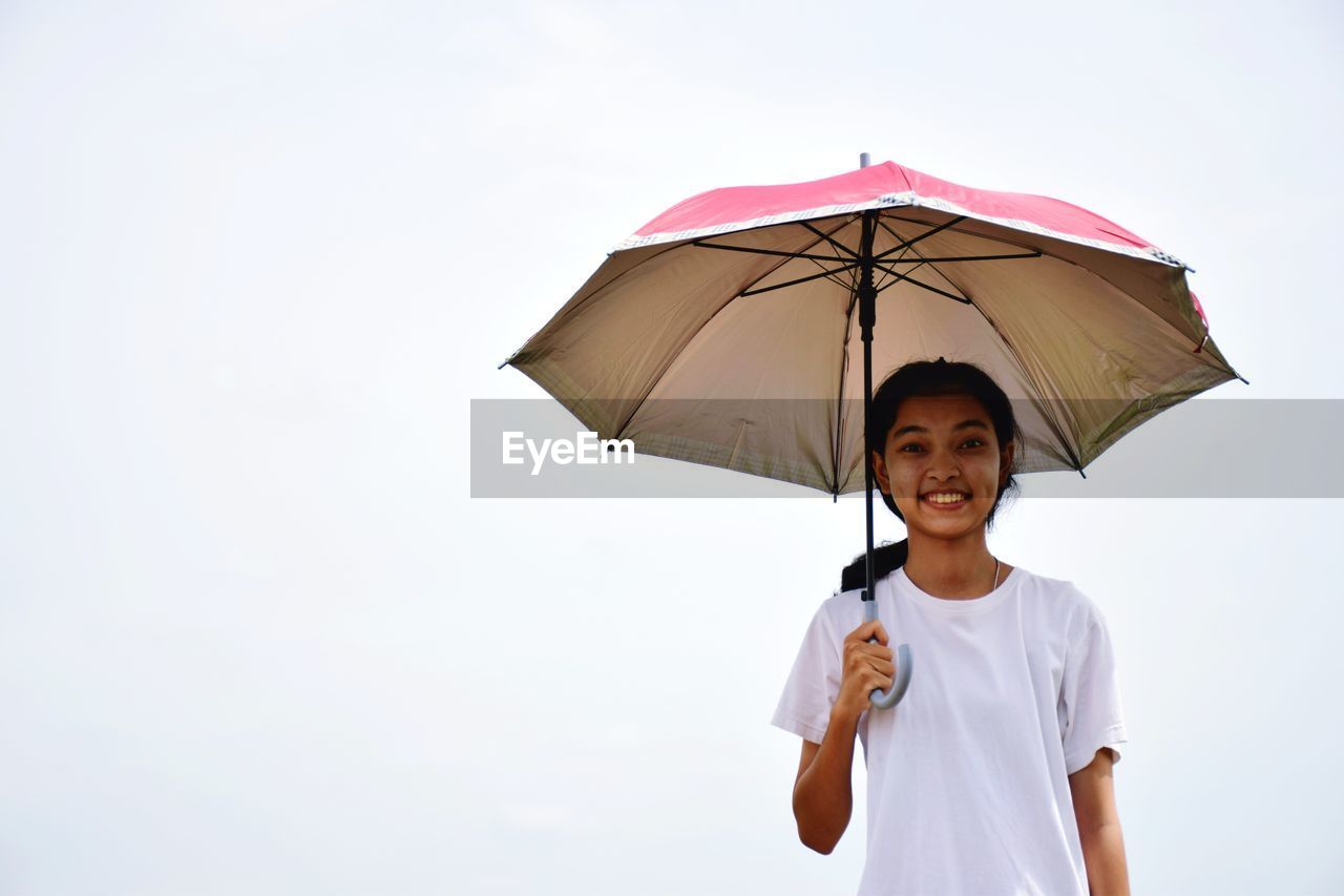 Portrait of teenage girl standing on rainy day