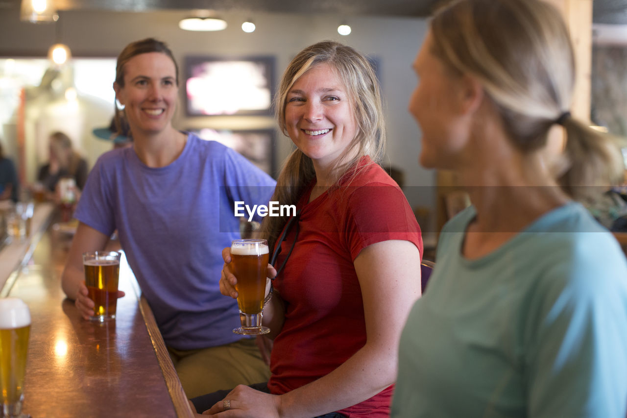 Three female friends enjoy a beer at a brewery in government camp, or.