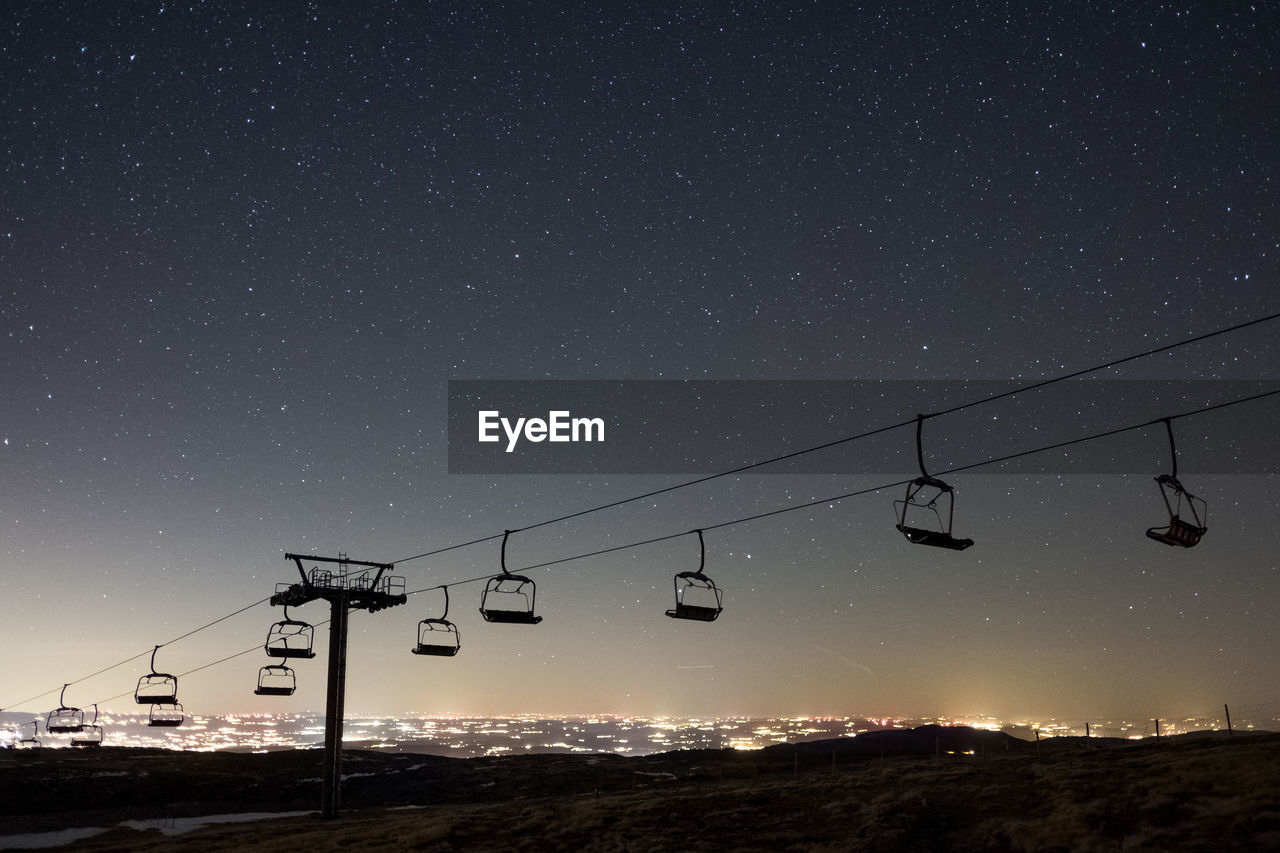 LOW ANGLE VIEW OF SKI LIFT AT NIGHT