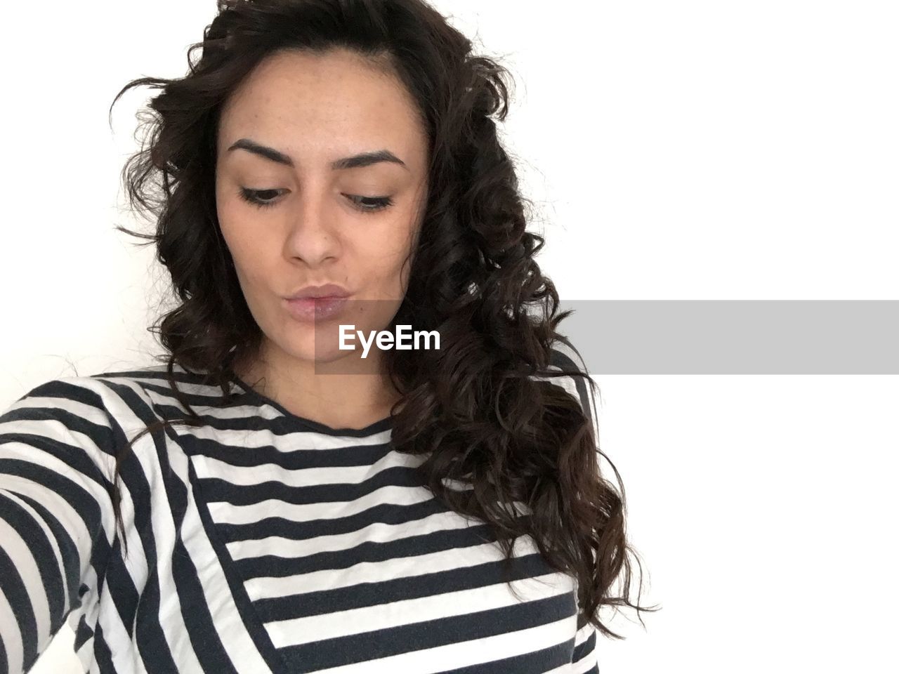 Young woman wearing striped t-shirt against white background