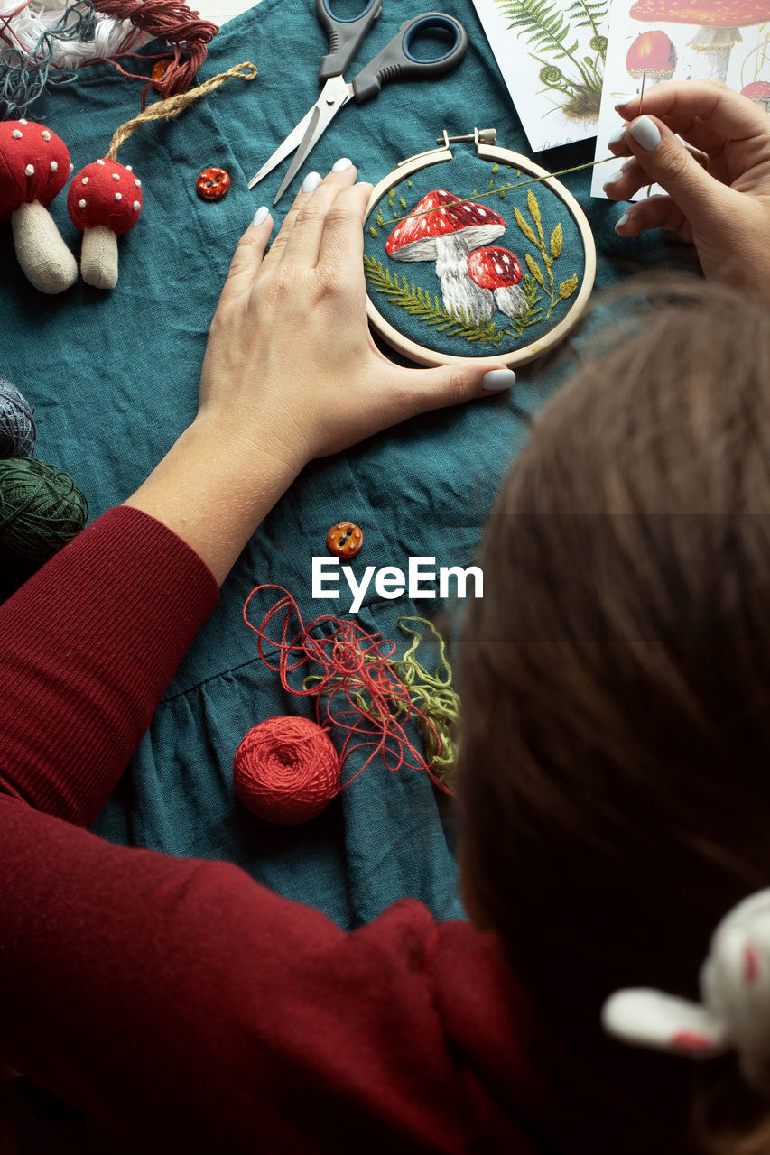 Flat lay with handmade fly agaric mushroom embroidery on dress