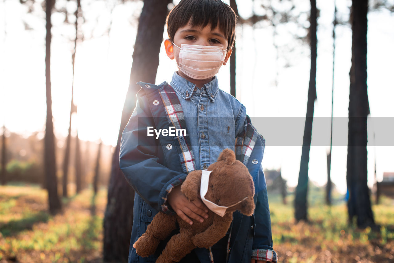 PORTRAIT OF BOY WITH TOY ON FIELD