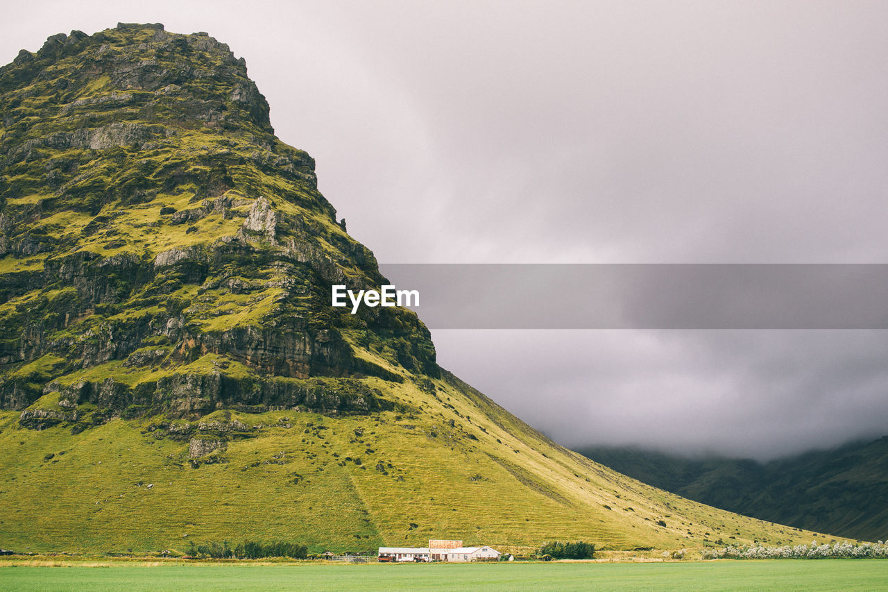 Scenic view of majestic mountain against cloudy sky