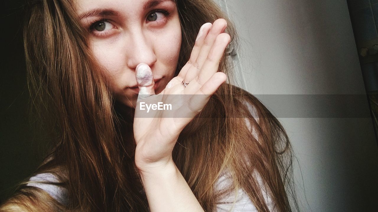 Portrait of young woman with long hair at home