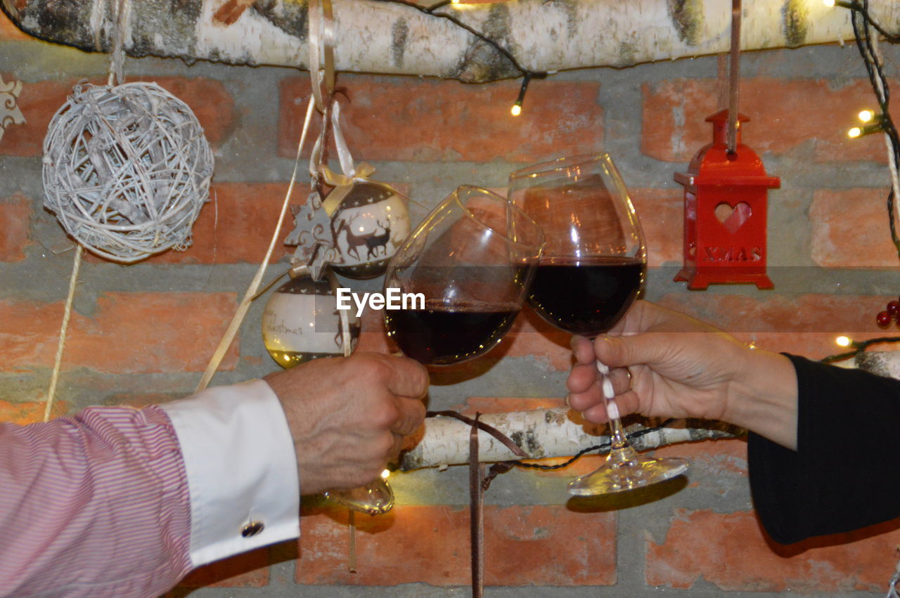 Cropped hands toasting wineglasses