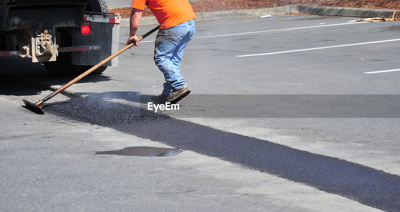 Man repairing potholes on the street.