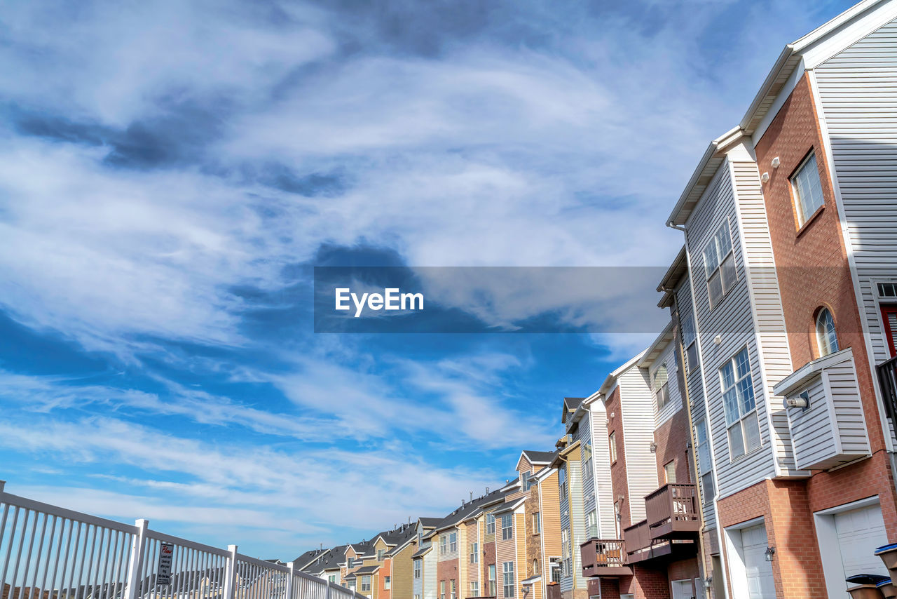 LOW ANGLE VIEW OF BUILDINGS AGAINST CLOUDY SKY