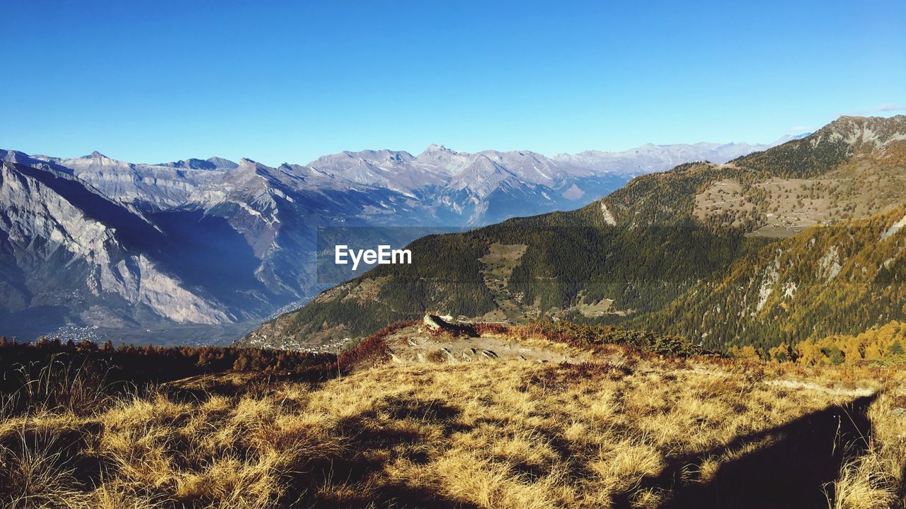 Scenic view of mountain range against blue sky