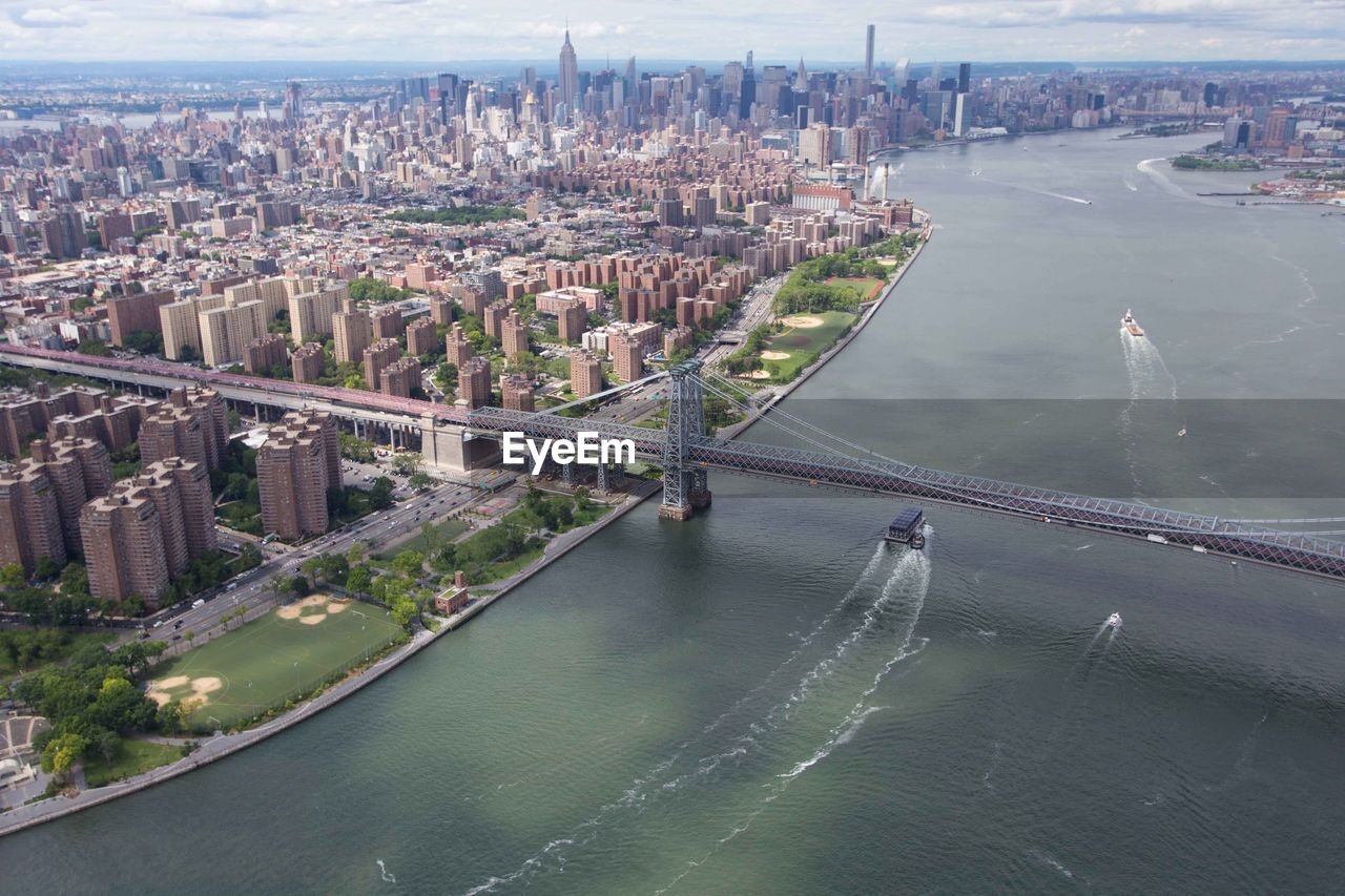 HIGH ANGLE VIEW OF BRIDGE OVER RIVER WITH CITYSCAPE IN BACKGROUND