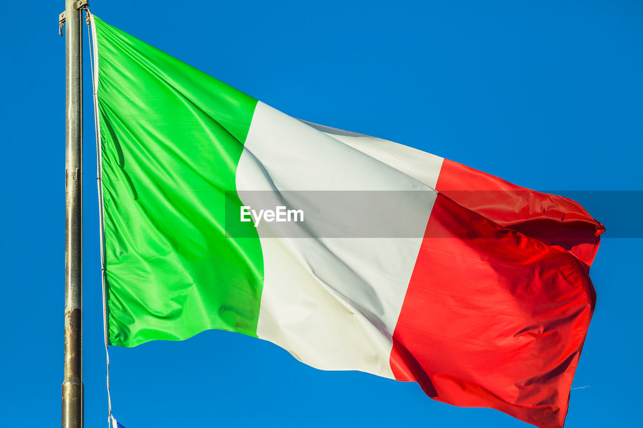 Low angle view of italian flag against clear blue sky