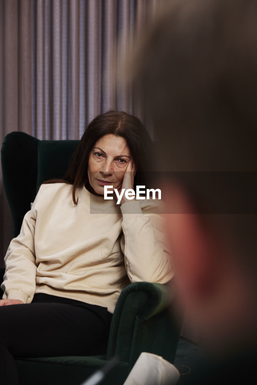 Female patient sitting in armchair at therapy session