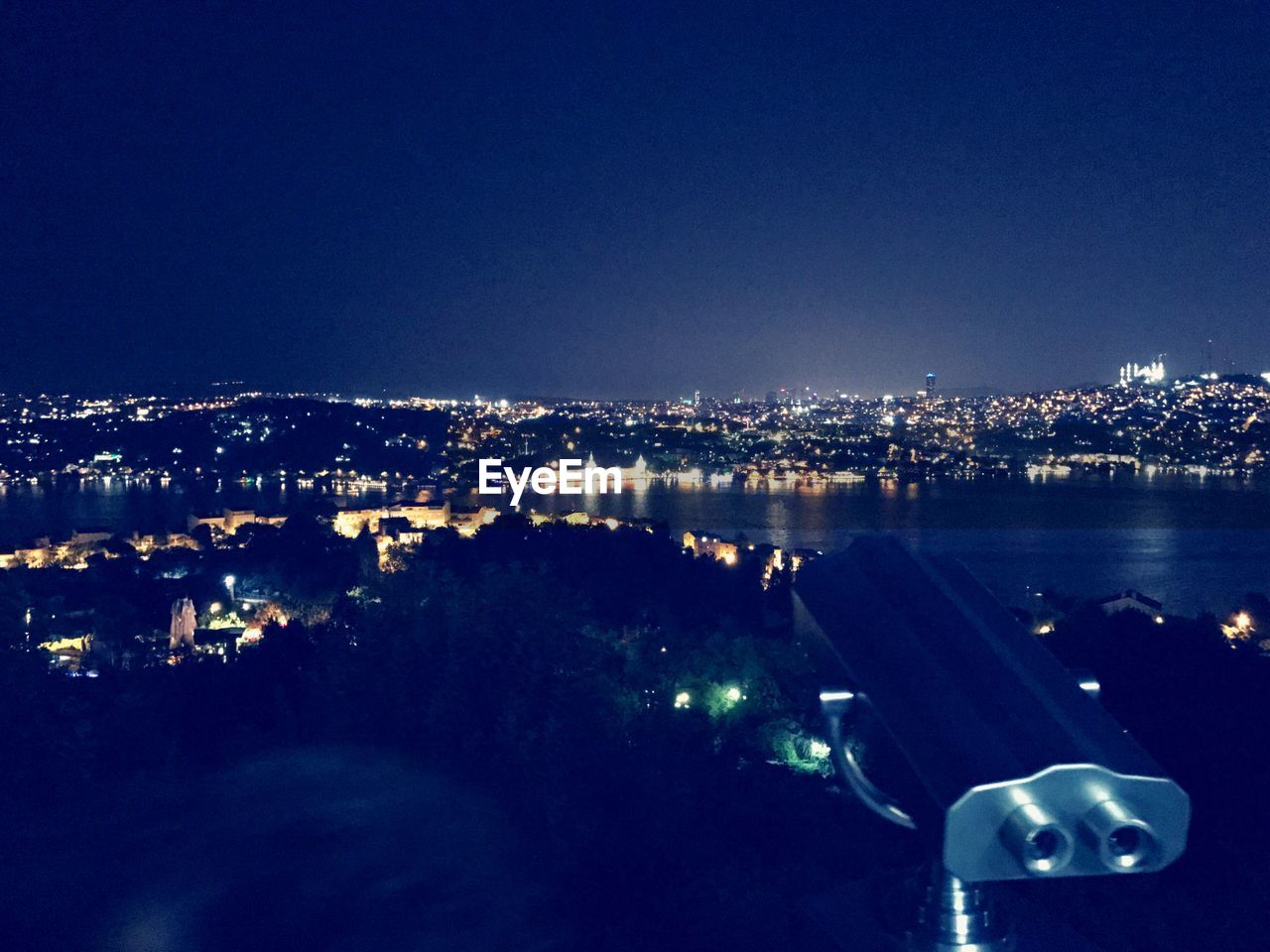 Aerial view of illuminated cityscape against clear blue sky