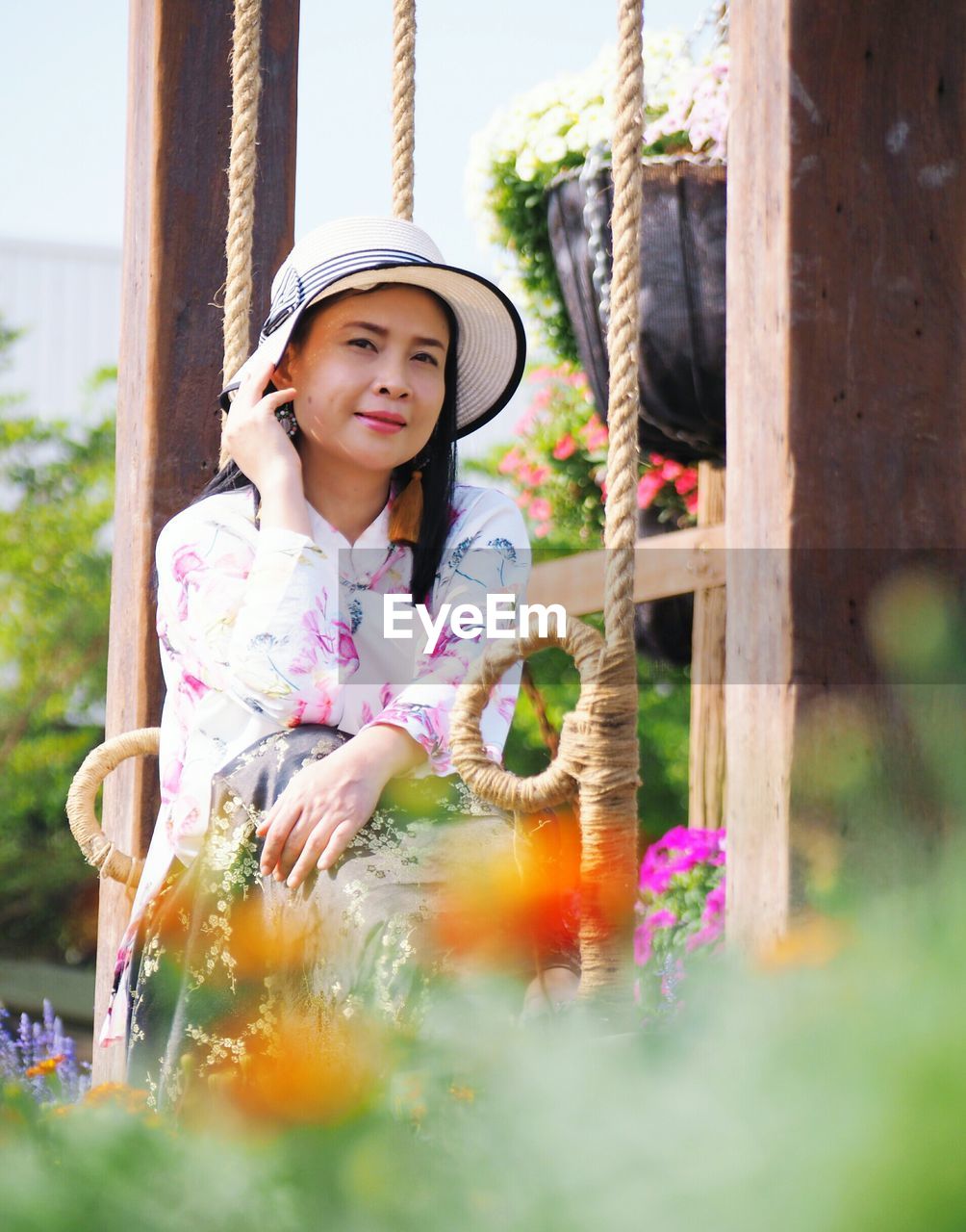 Portrait of woman sitting by plants