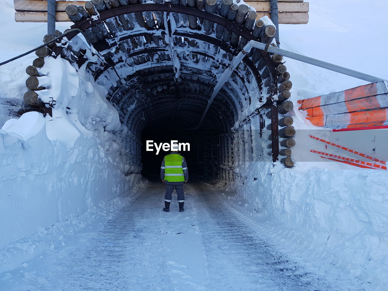 Rear view of manual worker standing in tunnel during winter
