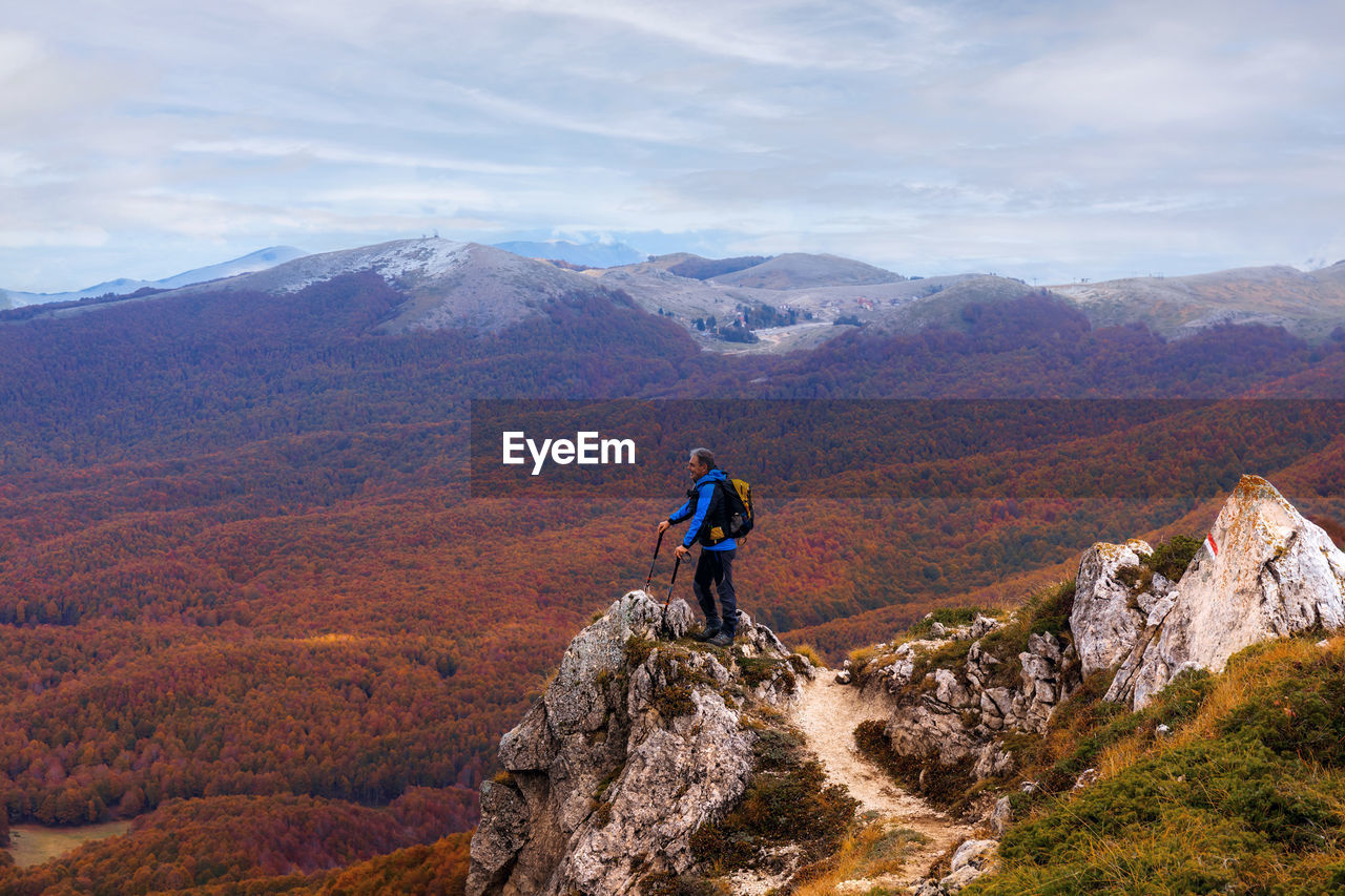 Rear view of man looking at mountain against sky