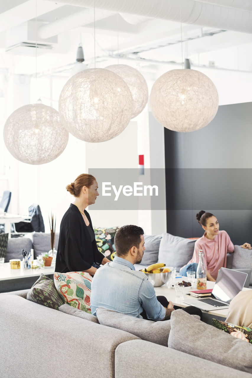 Business people sitting on sofa during meeting in office lobby