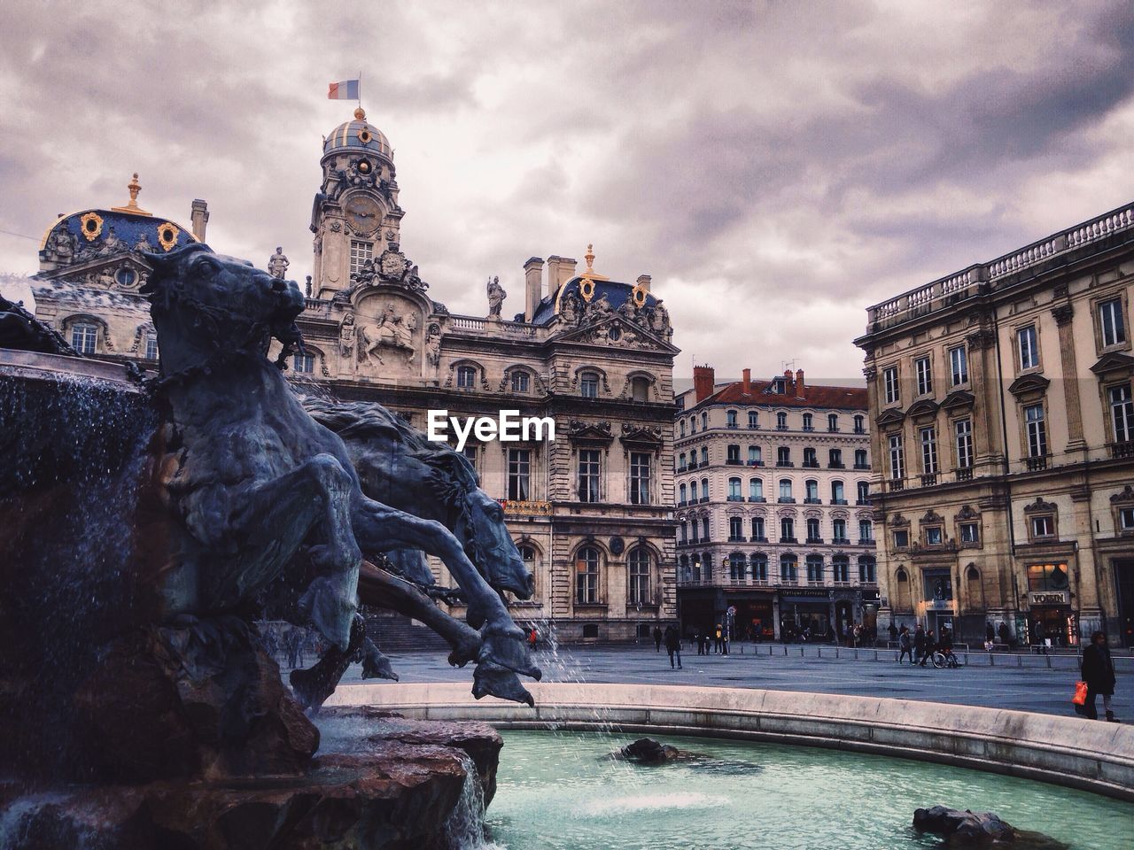 Fontaine bartholdi against historic building in city